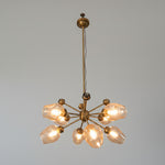 A Mid-Century Modern Sputnik hanging light with a brass finish and multiple arms extending outward with glass globe fixtures.