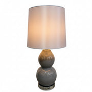 Gray table lamp with a white shade on a light gray background